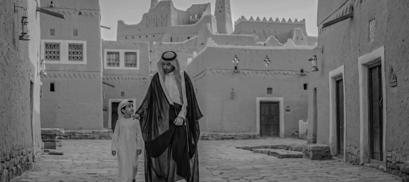 شخصٌ بالزيّ التقليدي في زقاقٍ تراثي